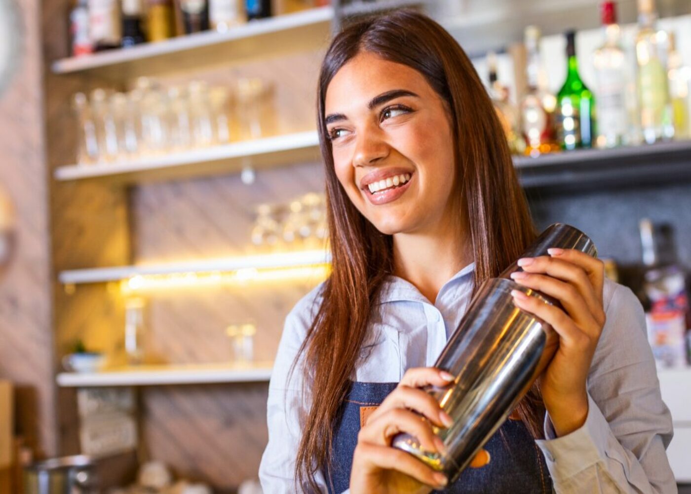 Barkeeperin mixt einen Cocktail hinter der Bar